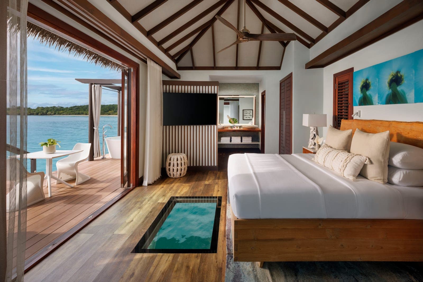 Blue Mahoe Overwater Butler Villa bedroom at Sandals South Coast, offering complete immersion with the turquoise Caribbean Sea below